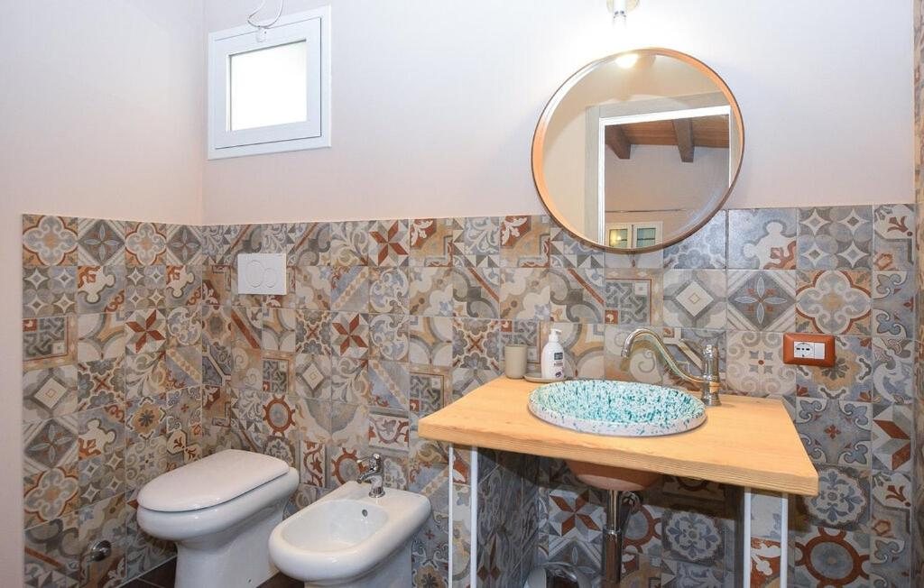 Il bagno della Camera Quadrupla con il lavabo decorato su piano in legno, il wc e il bidet
