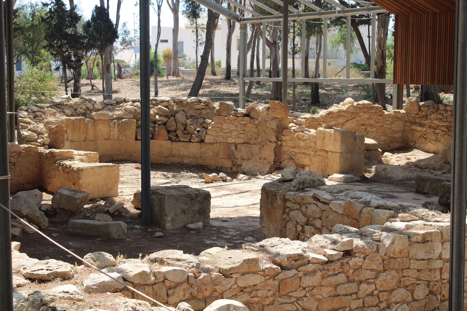 Muri in pietra di un edificio tardoantico nel parco archeologico di Kaukana, sotto una tettoia.