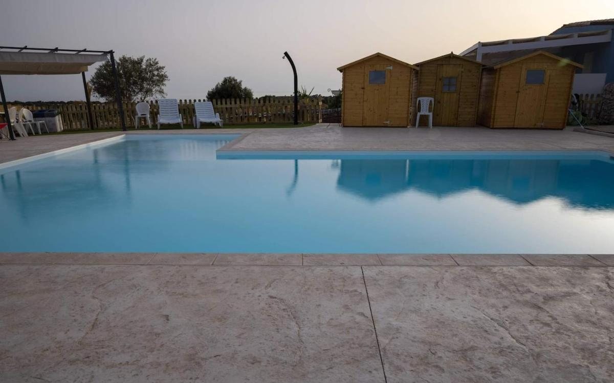 L'acqua calma della piscina e le casette in legno sul fondo