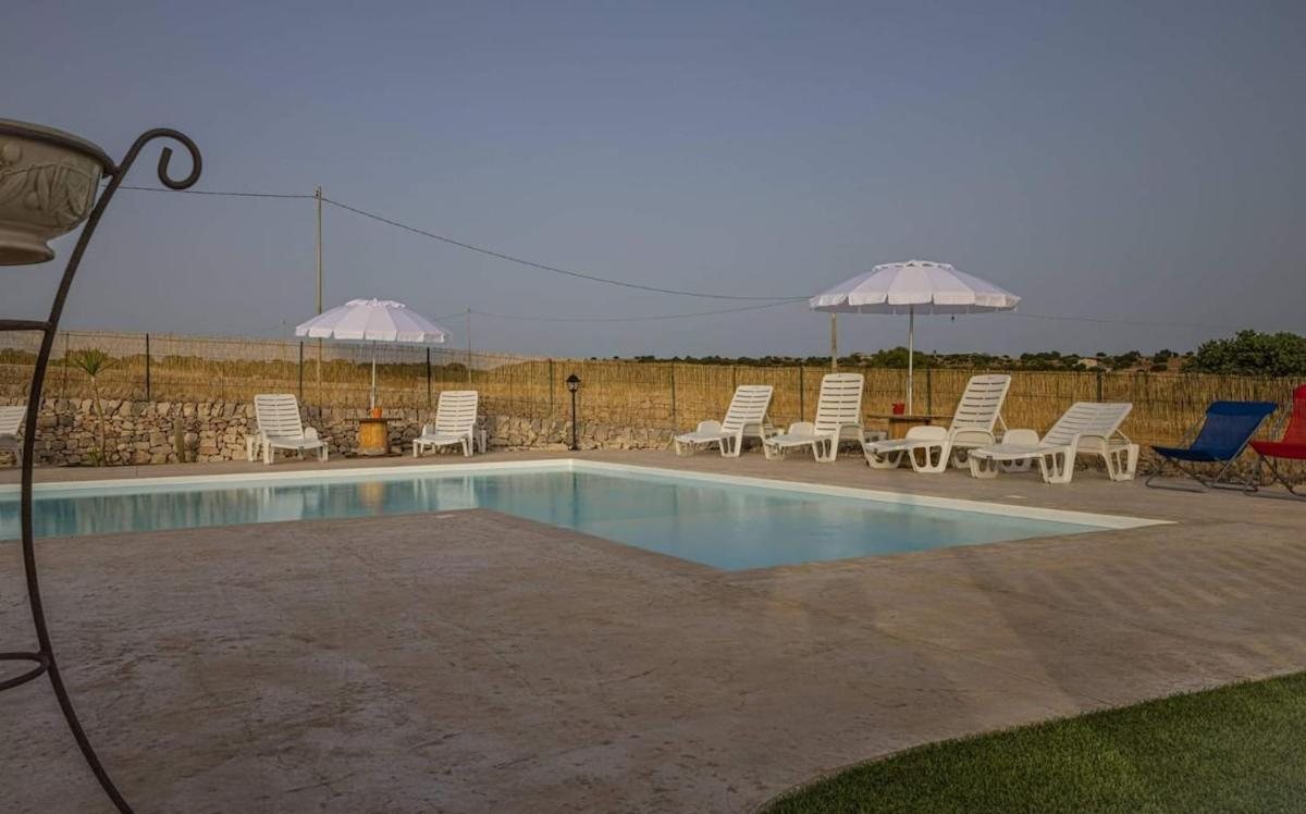La piscina al crepuscolo con gli ombrelloni e le luci accese