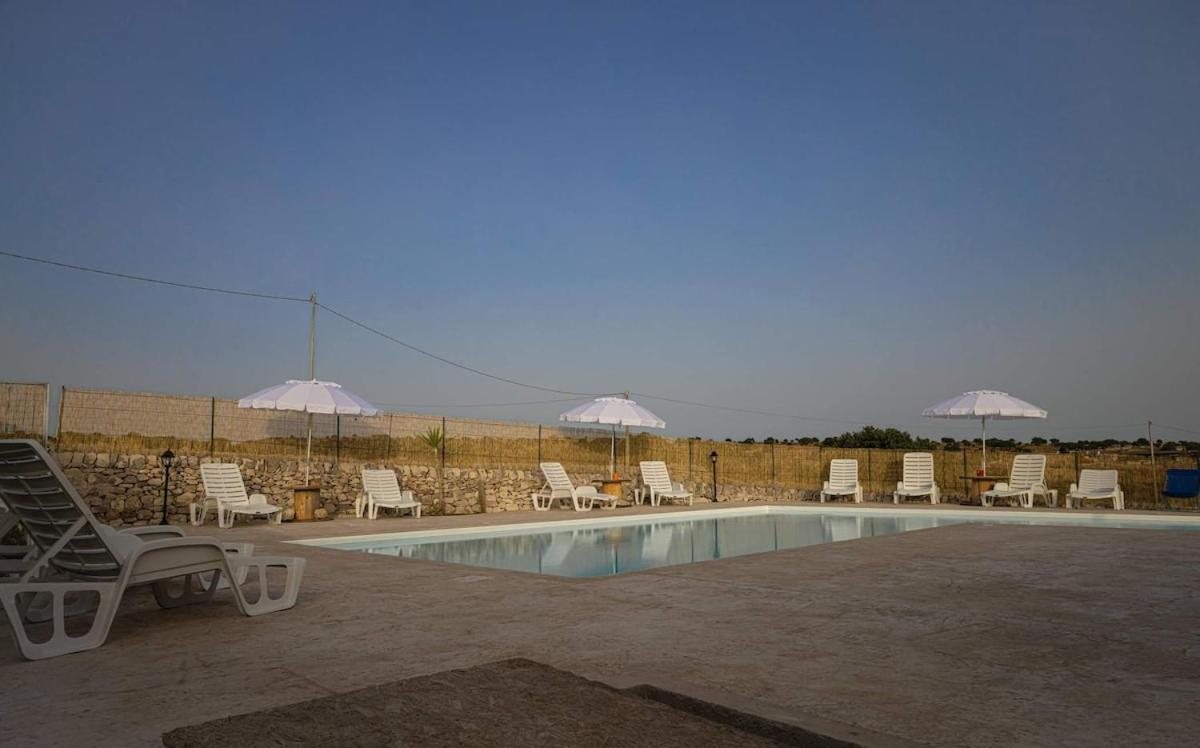 La piscina nella sera d'estate con gli ombrelloni chiusi