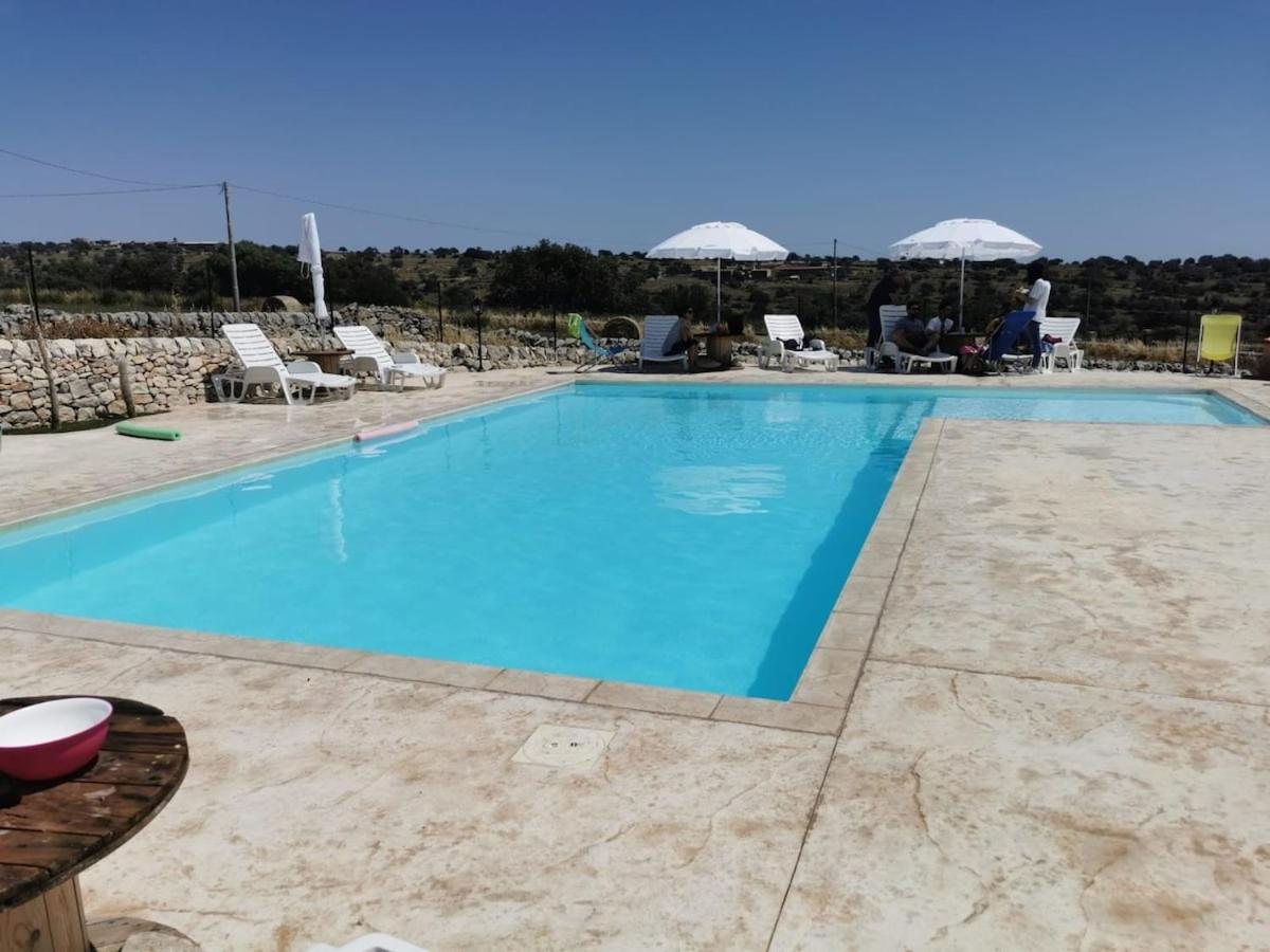 La piscina nel pomeriggio di sole con gli ombrelloni