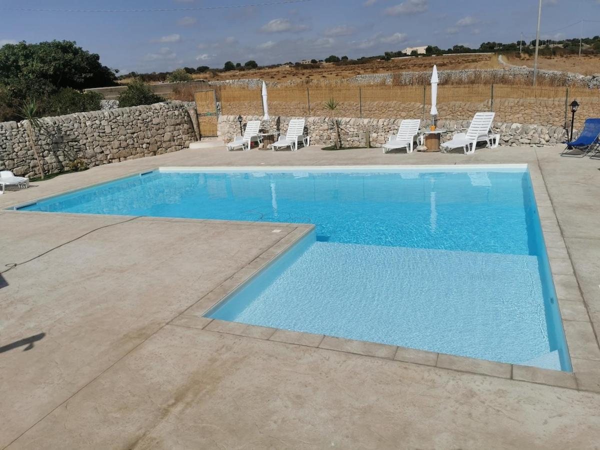La piscina con la zona bassa per i bambini e i lettini lungo il muro a secco
