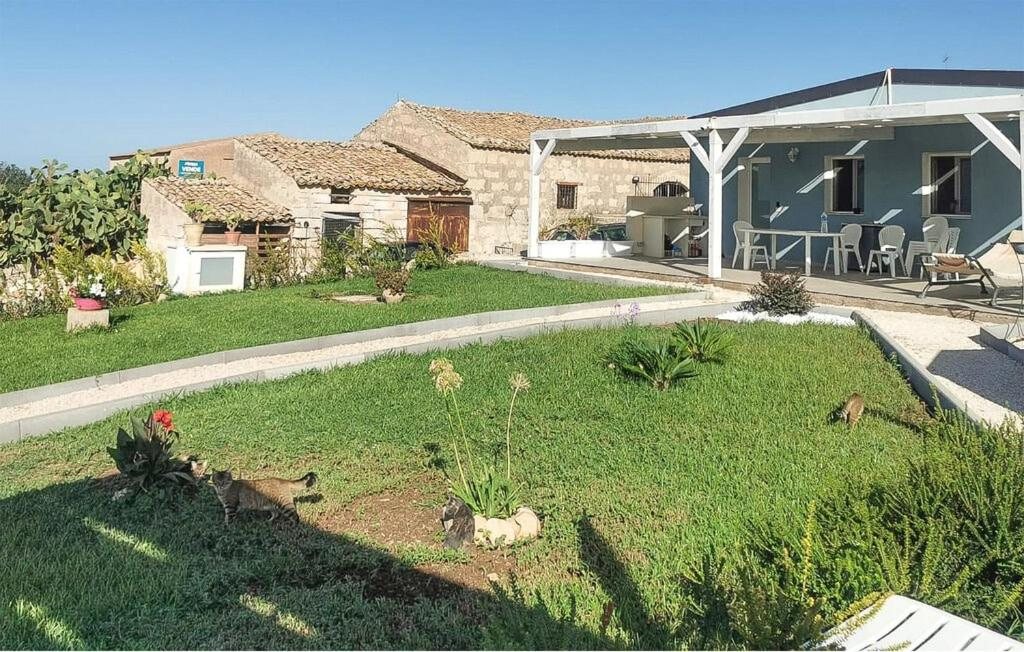 La villa con la facciata in pietra, la veranda e il giardino fiorito