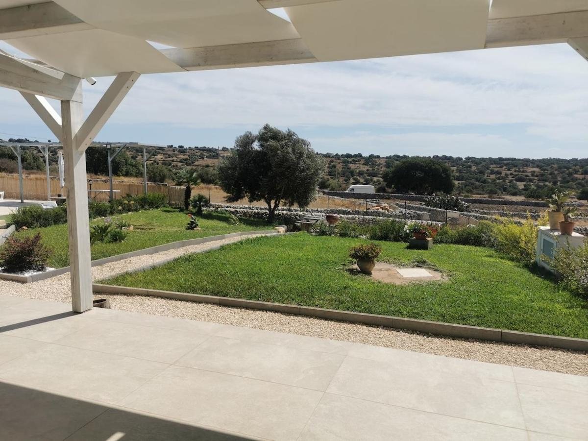 La veranda con il pergolato bianco che si affaccia sul prato, sugli ulivi e sulla campagna